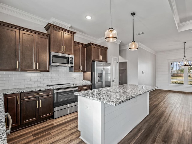 kitchen featuring hanging light fixtures, light stone counters, and stainless steel appliances