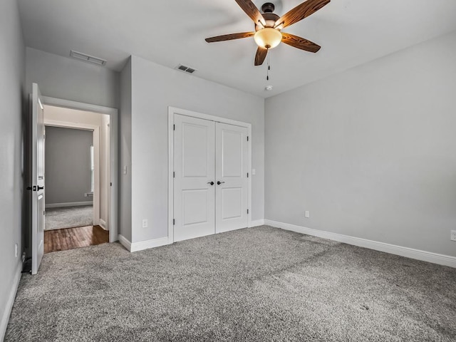 unfurnished bedroom with carpet, visible vents, and a closet