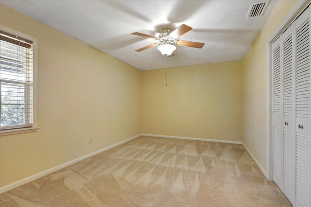 unfurnished bedroom with light colored carpet, a closet, visible vents, and baseboards