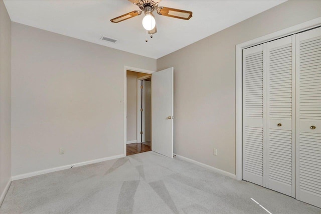 unfurnished bedroom with visible vents, baseboards, a closet, and light colored carpet