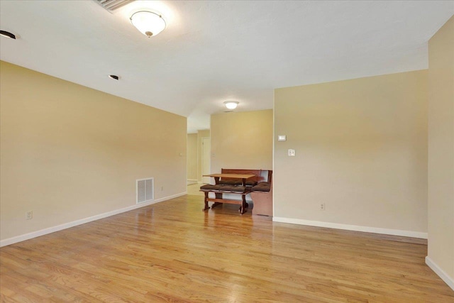 unfurnished room featuring baseboards, visible vents, and light wood-style floors