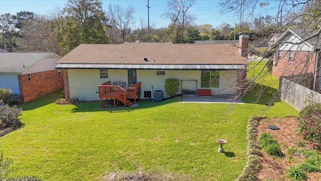 rear view of house with a chimney, a shingled roof, a lawn, a patio area, and central AC