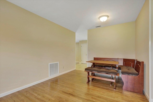 living area with light wood-type flooring, visible vents, and baseboards