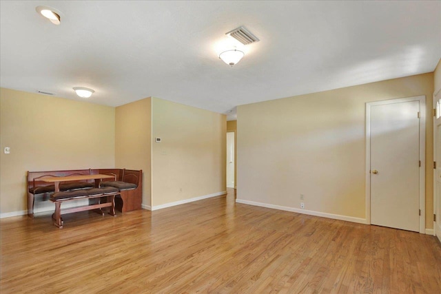 empty room with visible vents, light wood-style flooring, and baseboards