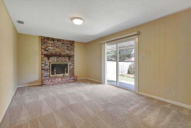 unfurnished living room with a brick fireplace, carpet flooring, visible vents, and baseboards