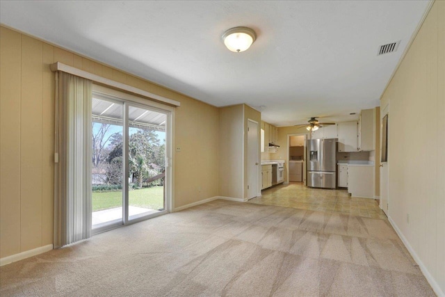 unfurnished living room featuring light carpet, baseboards, and visible vents