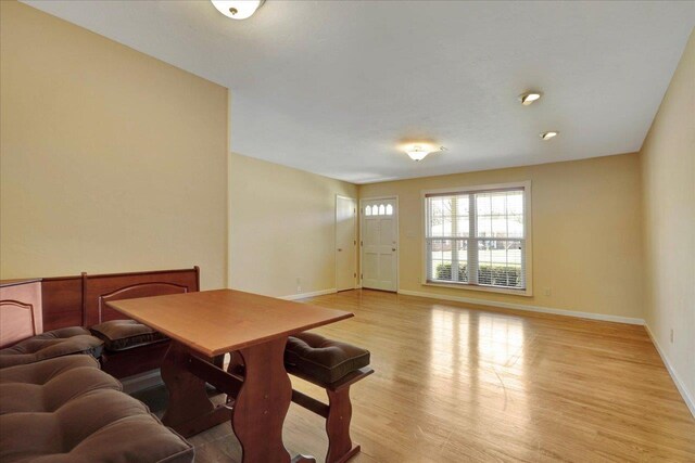 dining space with light wood-style flooring and baseboards