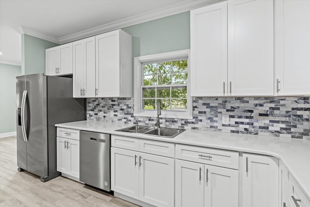 kitchen featuring a sink, light countertops, ornamental molding, stainless steel appliances, and white cabinetry