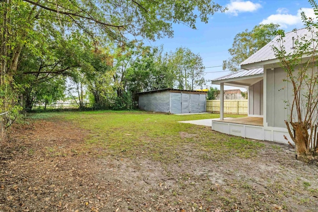 view of yard featuring fence and an outbuilding