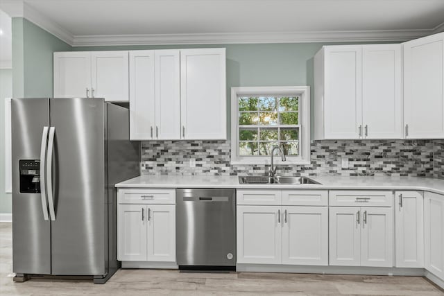 kitchen featuring a sink, light countertops, crown molding, and stainless steel appliances