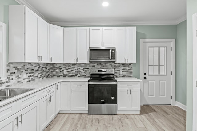 kitchen featuring decorative backsplash, light wood-style floors, light countertops, white cabinetry, and stainless steel appliances