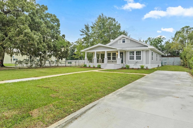 bungalow-style house with a porch, fence, and a front yard