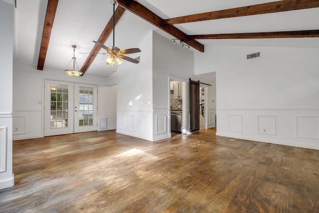 3200 Tallavana Trl, Havana, FL 32333 - unfurnished living room featuring a decorative wall, a barn door, ceiling fan, hardwood / wood-style flooring, and wainscoting