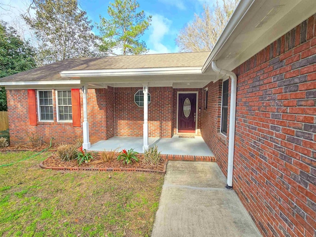 entrance to property featuring a lawn