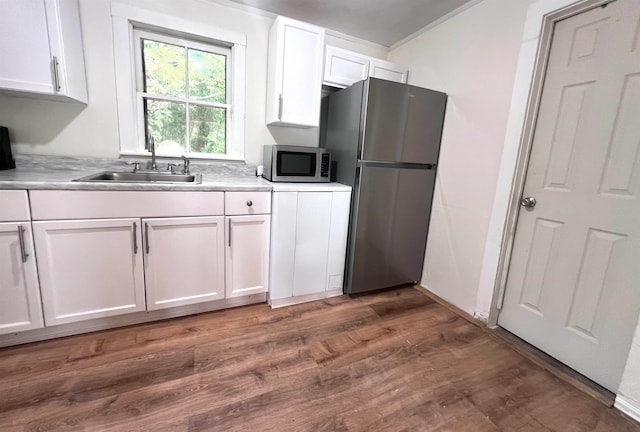 kitchen with dark hardwood / wood-style flooring, white cabinets, sink, crown molding, and appliances with stainless steel finishes