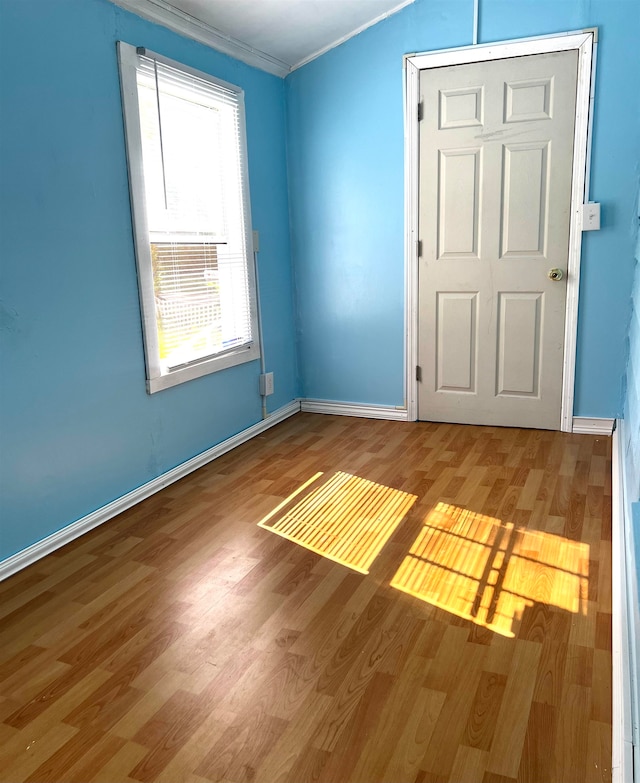 unfurnished room with hardwood / wood-style flooring and crown molding