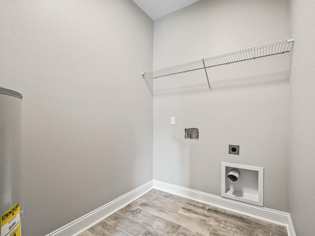 240 Ante Beppum Loop, Carrabelle, FL 32322 - laundry area with electric dryer hookup, washer hookup, baseboards, wood finished floors, and water heater