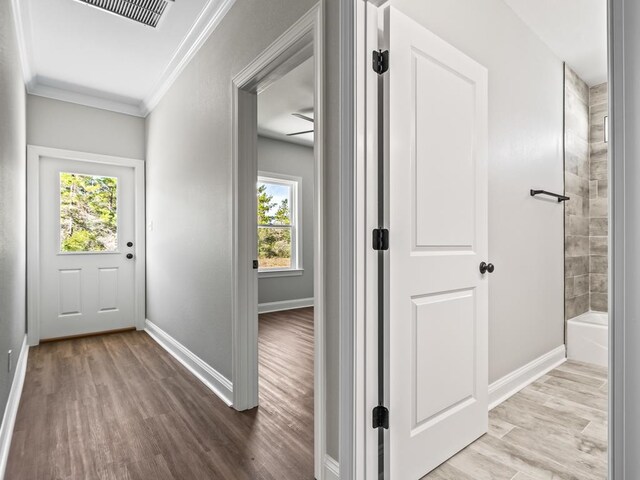 hallway featuring light wood-type flooring and crown molding