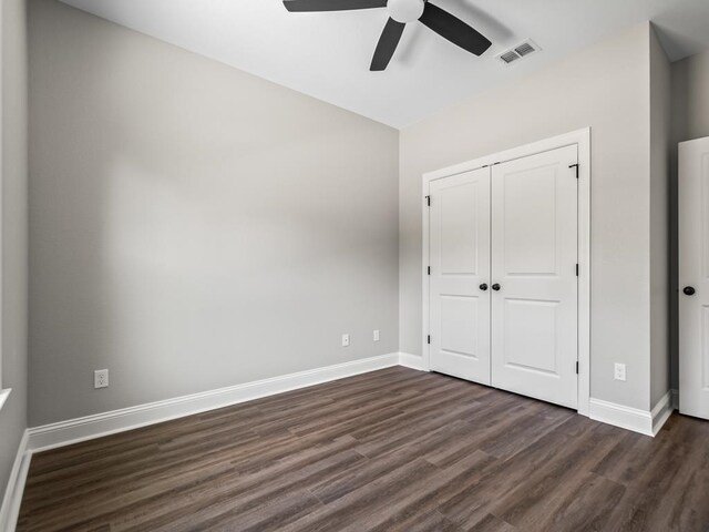 unfurnished bedroom with ceiling fan, dark hardwood / wood-style floors, and a closet