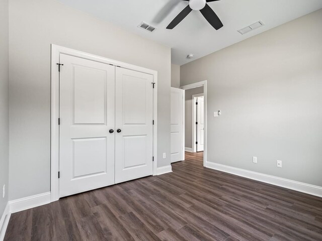 unfurnished bedroom with dark hardwood / wood-style flooring, ceiling fan, and a closet