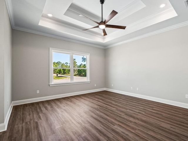 spare room with ornamental molding, dark hardwood / wood-style flooring, ceiling fan, and a raised ceiling