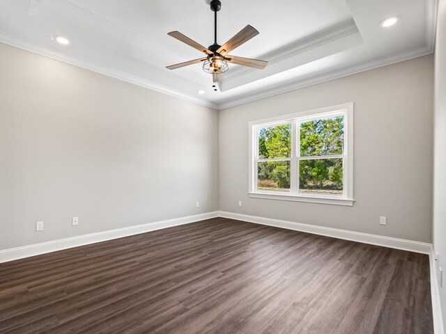 spare room with ornamental molding, ceiling fan, a tray ceiling, and dark hardwood / wood-style floors