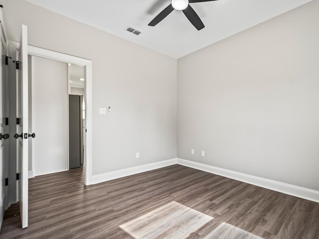 unfurnished room with dark wood-type flooring and ceiling fan