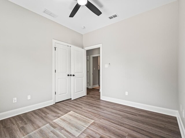 240 Ante Beppum Loop, Carrabelle, FL 32322 - unfurnished bedroom with baseboards, wood finished floors, ceiling fan, and a closet