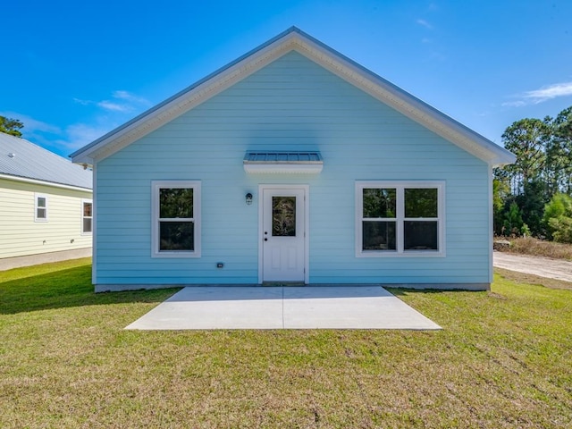 rear view of house featuring a yard and a patio area