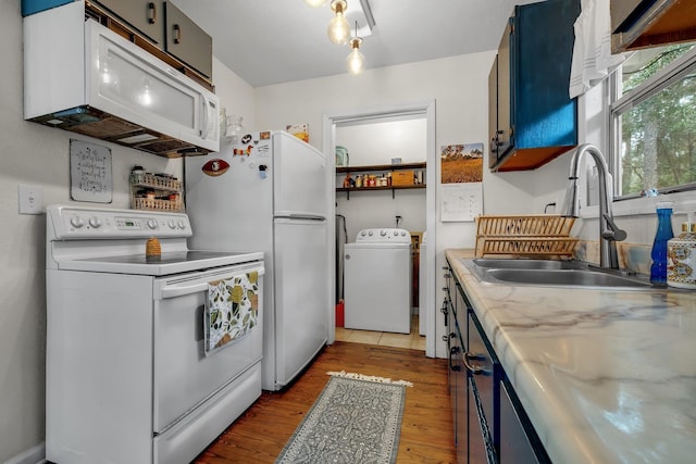 kitchen featuring blue cabinets, washer / dryer, sink, white appliances, and hardwood / wood-style floors