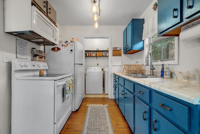 kitchen featuring sink, white appliances, light hardwood / wood-style flooring, washing machine and dryer, and blue cabinets