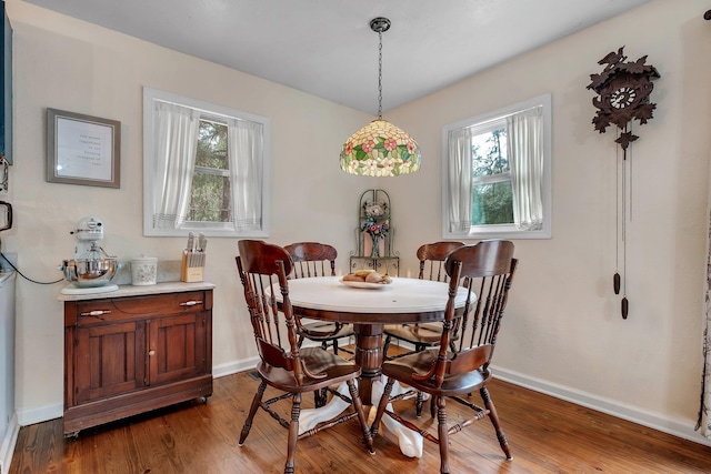 dining space with wood-type flooring