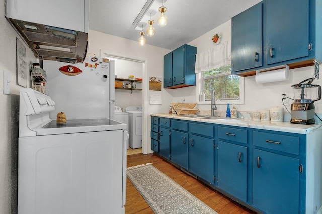 kitchen with blue cabinetry, sink, washing machine and clothes dryer, and light hardwood / wood-style floors