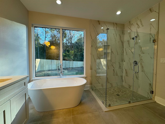 bathroom with tile patterned flooring, shower with separate bathtub, and vanity