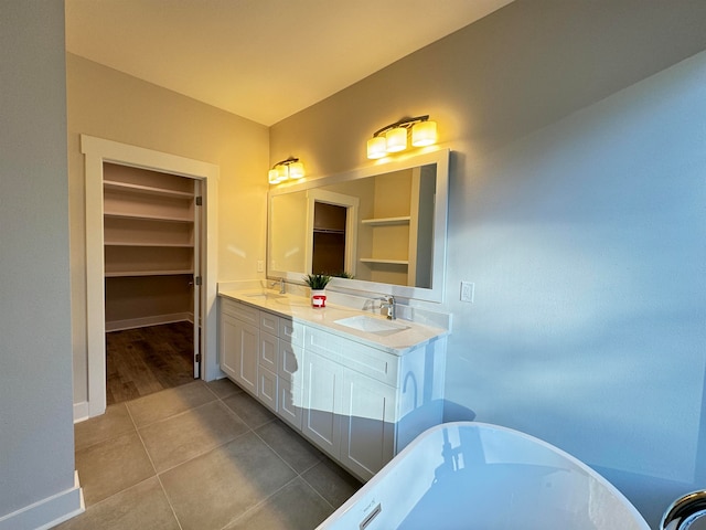 bathroom with a bathing tub, tile patterned flooring, and vanity