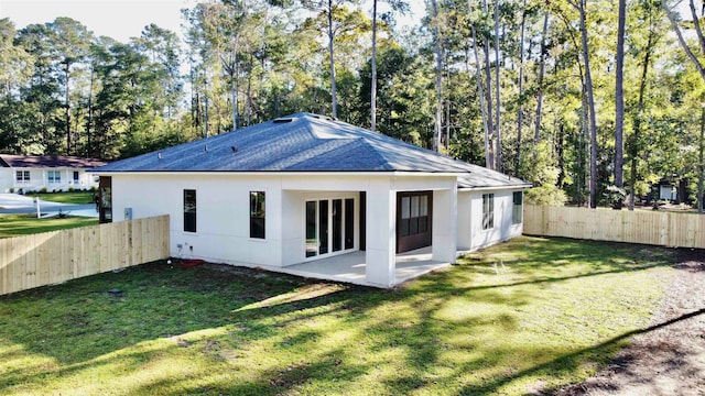 rear view of property featuring a yard and a patio