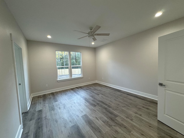 spare room featuring dark hardwood / wood-style flooring and ceiling fan