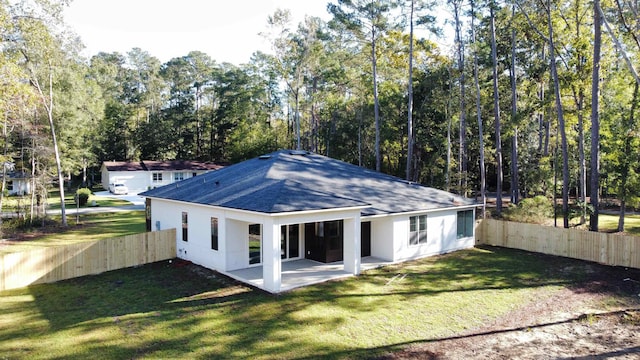 back of house with a lawn and a patio