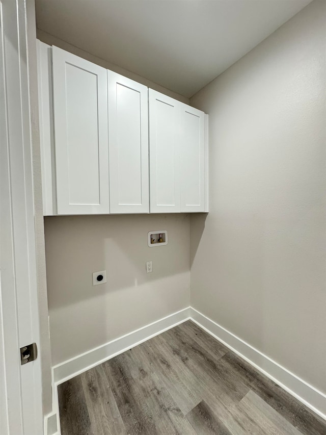 clothes washing area with electric dryer hookup, hookup for a washing machine, cabinets, and light hardwood / wood-style floors