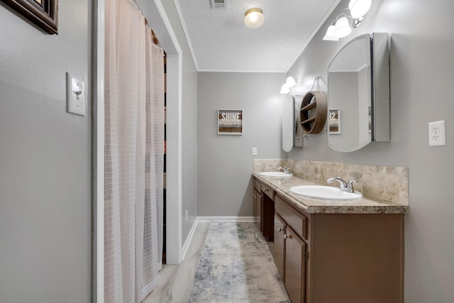 bathroom with vanity, crown molding, backsplash, and a textured ceiling