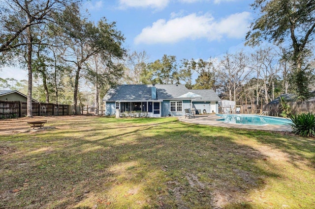 back of property featuring a fenced in pool, a sunroom, a yard, and a patio area