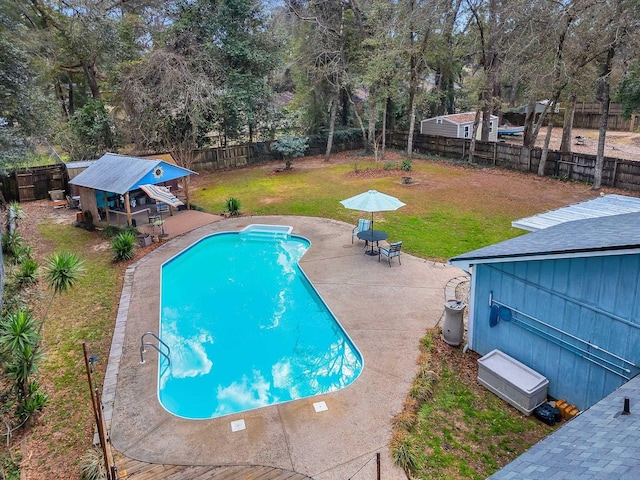 view of pool featuring exterior bar, a lawn, and a patio area