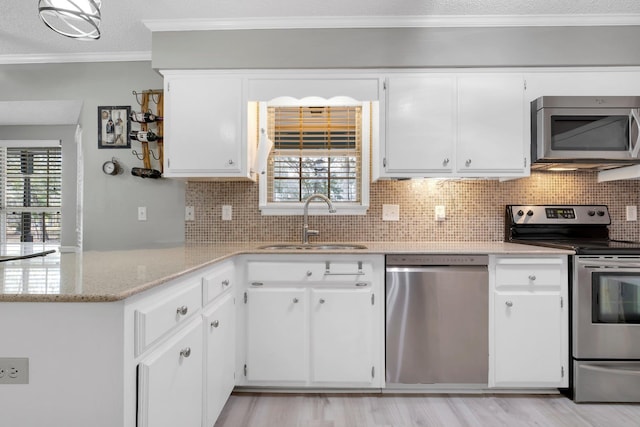 kitchen featuring stainless steel appliances, ornamental molding, sink, and white cabinets