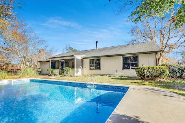 view of swimming pool with a yard and a sunroom