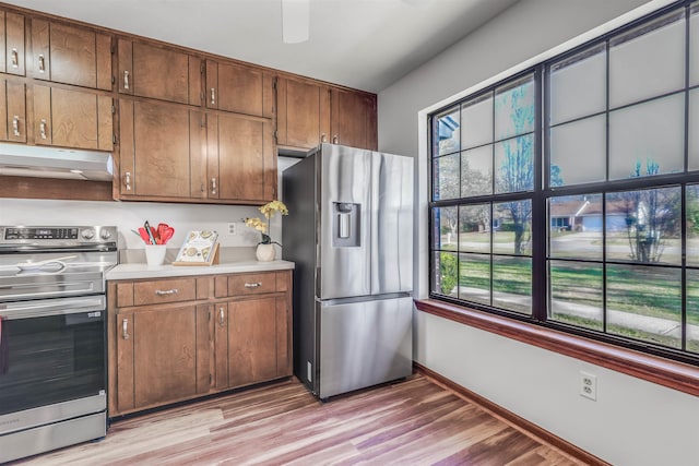 kitchen with a healthy amount of sunlight, appliances with stainless steel finishes, and light wood-type flooring