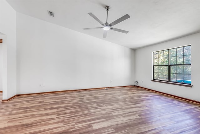 spare room with ceiling fan, vaulted ceiling, and light hardwood / wood-style flooring