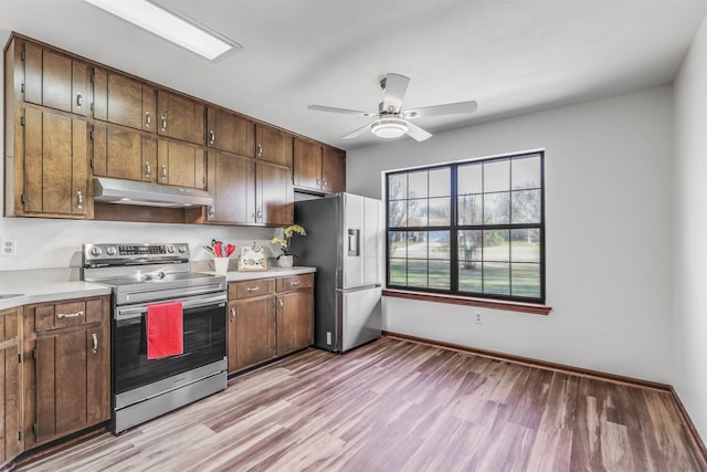 kitchen with stainless steel appliances, ceiling fan, and light wood-type flooring