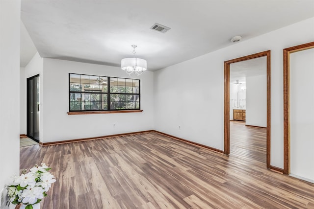 unfurnished dining area featuring hardwood / wood-style floors and a notable chandelier