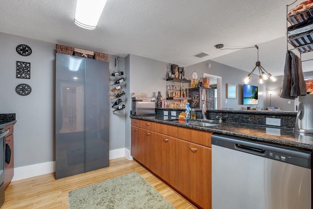 300 S Duval St # 508, Tallahassee, FL 32301 - kitchen featuring appliances with stainless steel finishes, light wood-type flooring, a textured ceiling, dark stone countertops, and pendant lighting