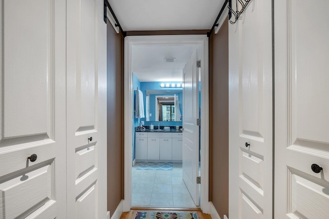 300 S Duval St # 508, Tallahassee, FL 32301 - hallway with a barn door, baseboards, and a sink